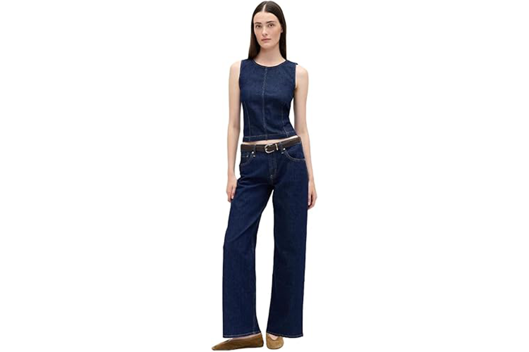 Woman modeling a dark denim sleeveless top and wide-leg jeans with a dark brown belt and tan flat shoes.