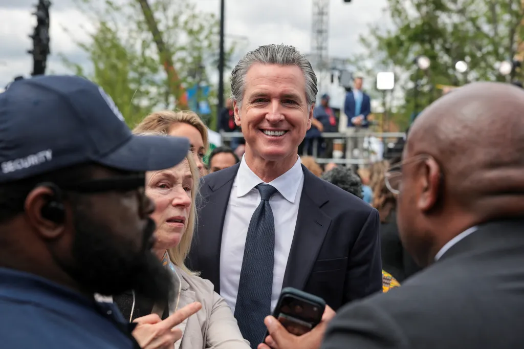 California Governor Gavin Newsom smiling at the camera at the opening of the Obama Presidential Center.