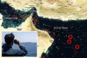 An illustration of a satellite map is seen showing the movement of ships in the Gulf of Oman, with red ships indicating those broadcasting their location, with an overlay of a US Sailor observing a commercial vessel through binoculars in the Arabian Sea.