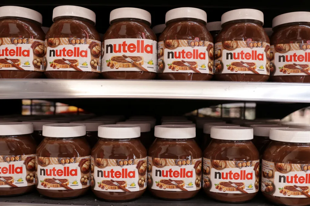 Jars of Nutella are displayed on a supermarket shelf.