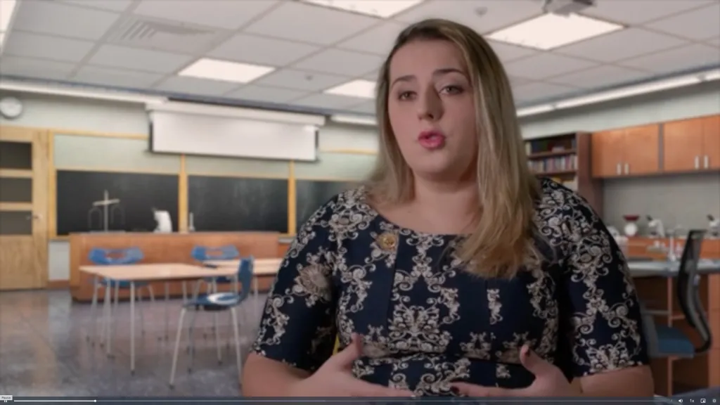 Jayda Pugliese, "American Dreamers" speaker, in a dark blue patterned dress.
