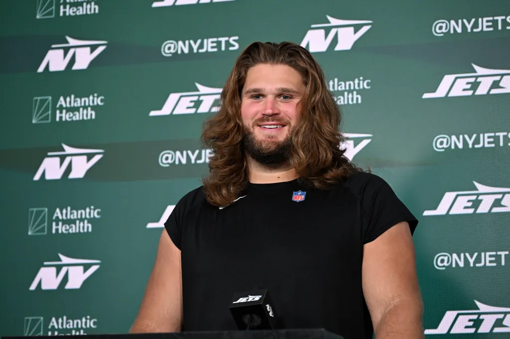 Joe Tippmann of the Jets smiles at a press conference.