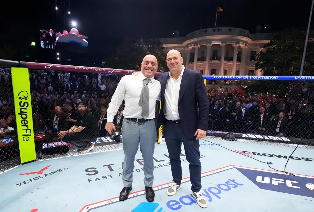 Joe Rogan and Dana White in the Octagon at UFC Freedom 250 with the White House in the background.