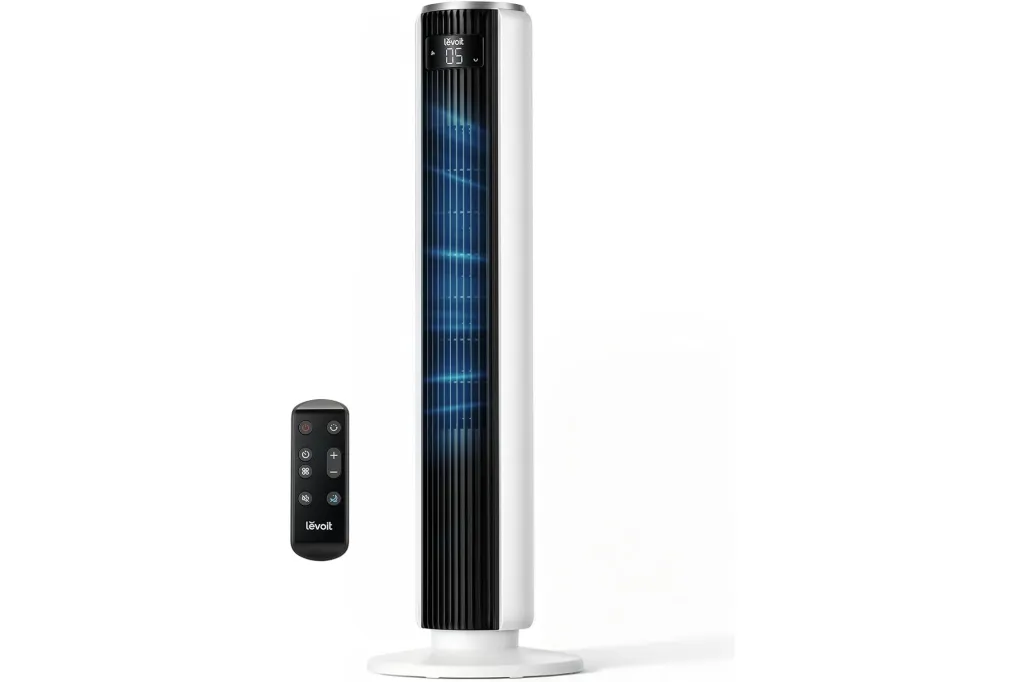 A white and black Levoit tower fan with a remote control.