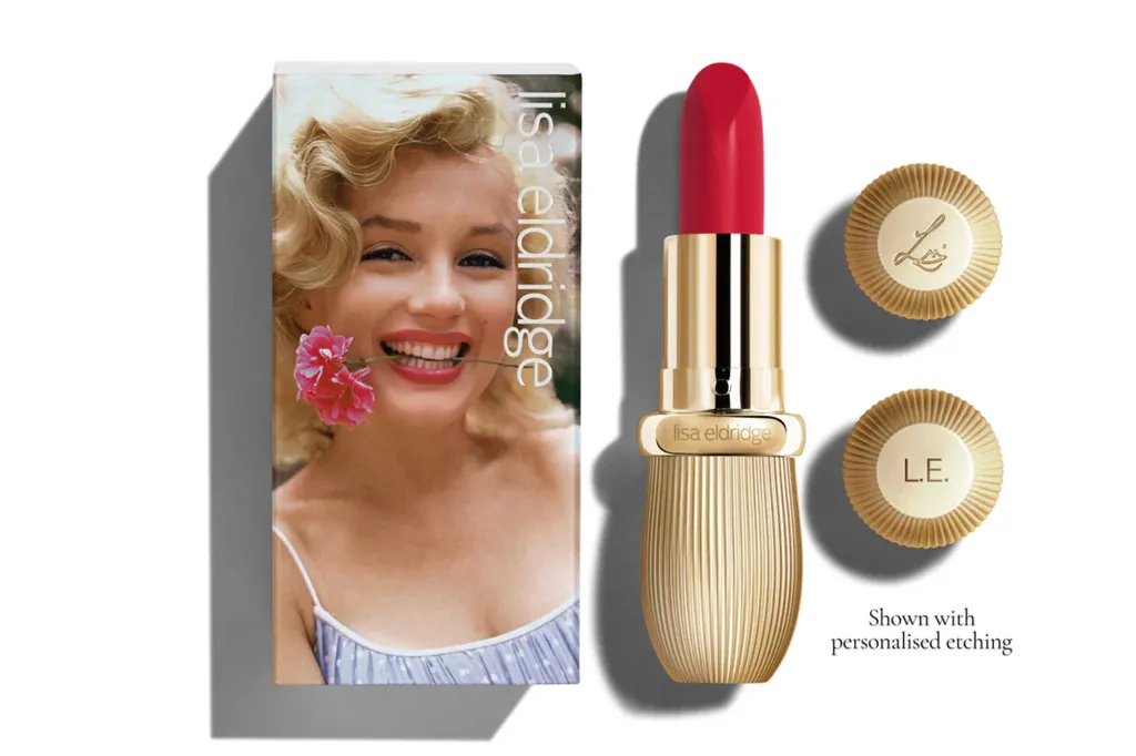 Lisa Eldridge lipstick in gold tube with red lipstick, next to the box featuring Marilyn Monroe holding a pink flower in her mouth.