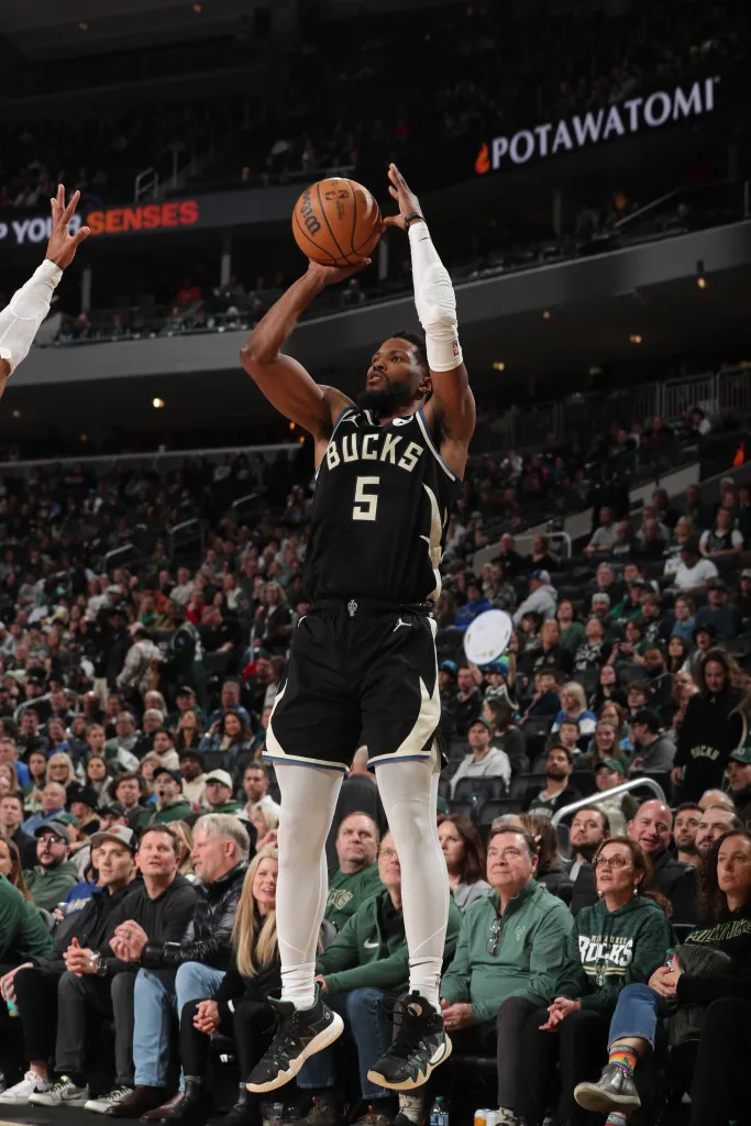 Milwaukee Bucks player Bobby Portis Jr. wearing a black uniform with "BUCKS 5" in white, mid-jump to shoot a basketball.