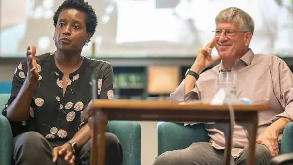 Marla Blow, new CEO of the Skoll Foundation, speaks while a man smiles.