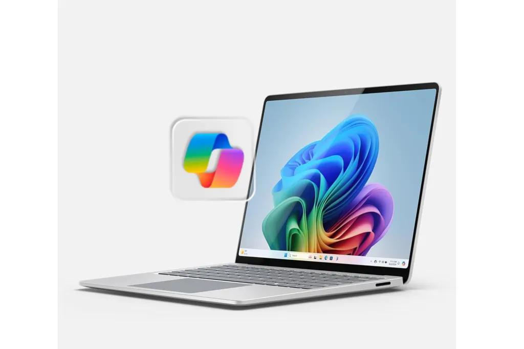 Silver laptop with a colorful abstract background on the screen and a blurred colorful ribbon icon floating next to it.