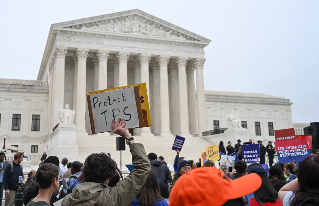A person holds a sign reading "Protect TPS" at a rally in front of the US Supreme Court.