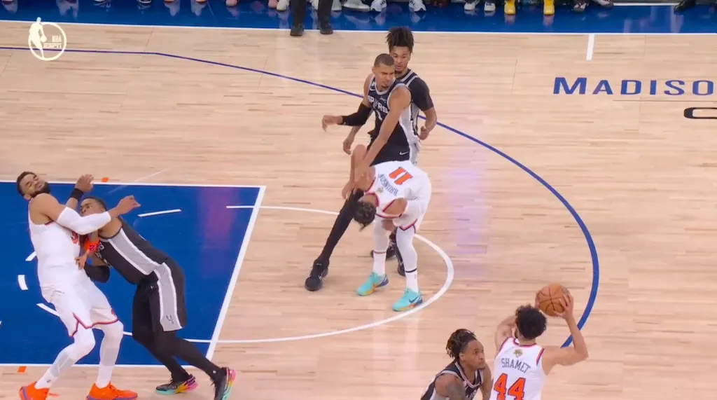Basketball players from the Spurs and Knicks during a game.