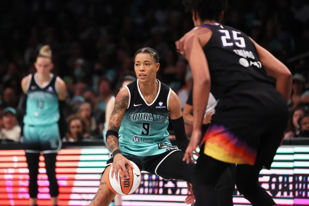 New York Liberty guard Natasha Cloud (9) dribbles the ball against a Phoenix Mercury opponent.