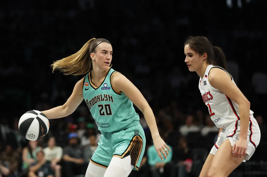 New York Liberty guard Sabrina Ionescu dribbling the ball while defended by Washington Mystics guard Sonia Citron.