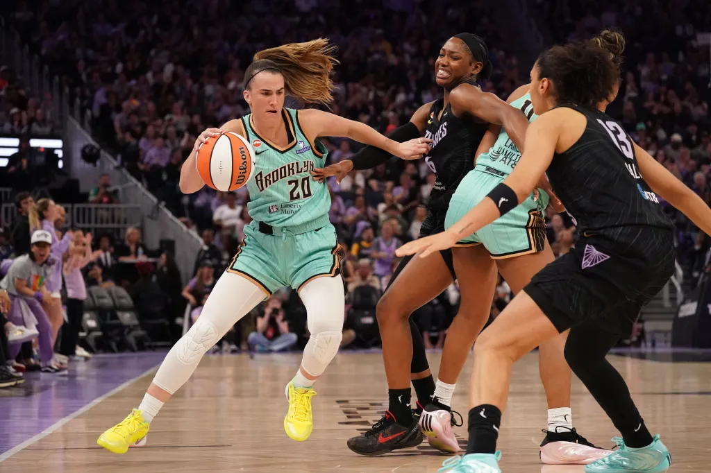 New York Liberty guard Sabrina Ionescu dribbling against Golden State Valkyries guard-forward Kaila Charles and forward Janelle Salaun.