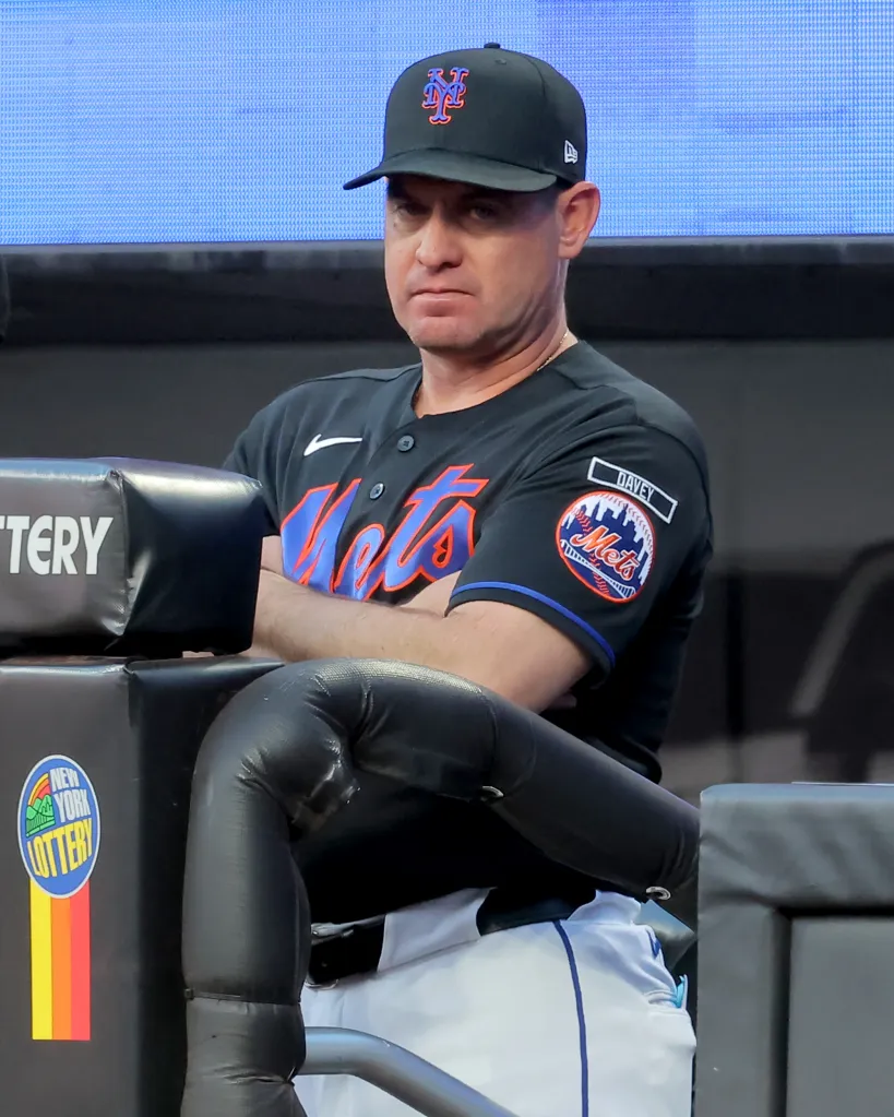 New York Mets manager Carlos Mendoza watching from the dugout.