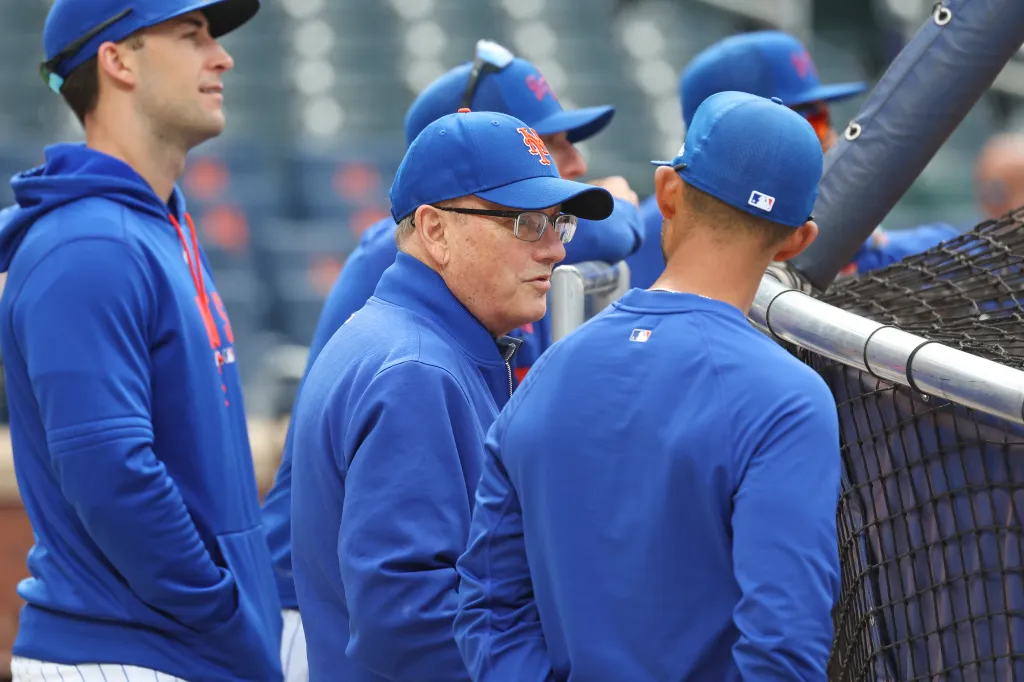 New York Mets owner Steve Cohen speaking with bench coach Kai Correa before a game.