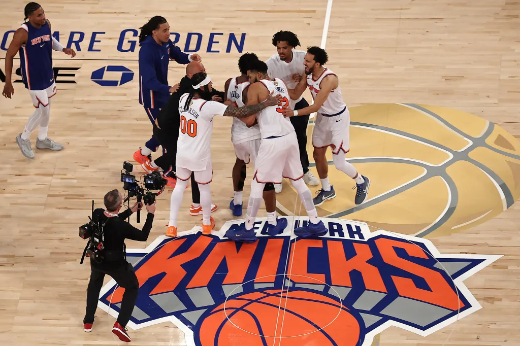 New York Knicks players celebrating together on a basketball court.