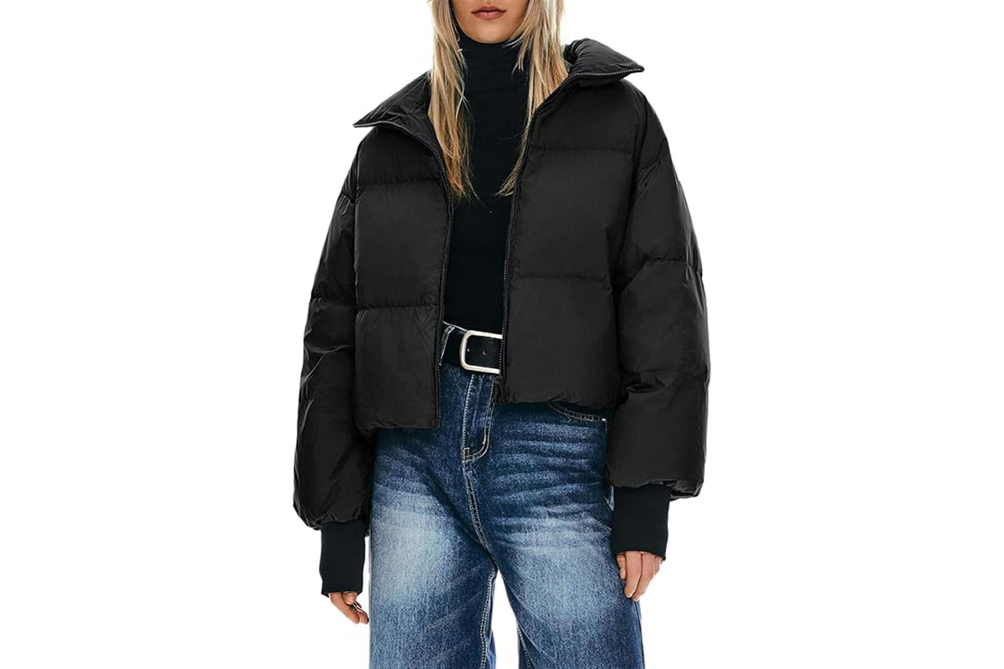 A person wearing a black cropped puffer jacket, black turtleneck, and blue jeans.