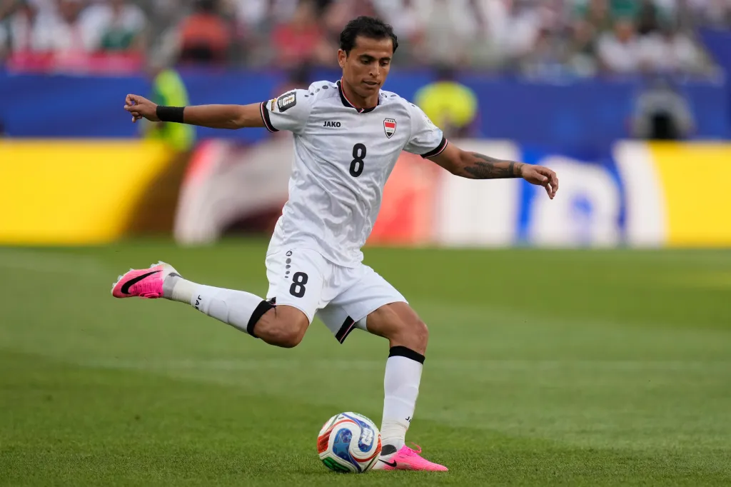 Iraq's Ibrahim Bayesh (8) passes the ball during a soccer match.