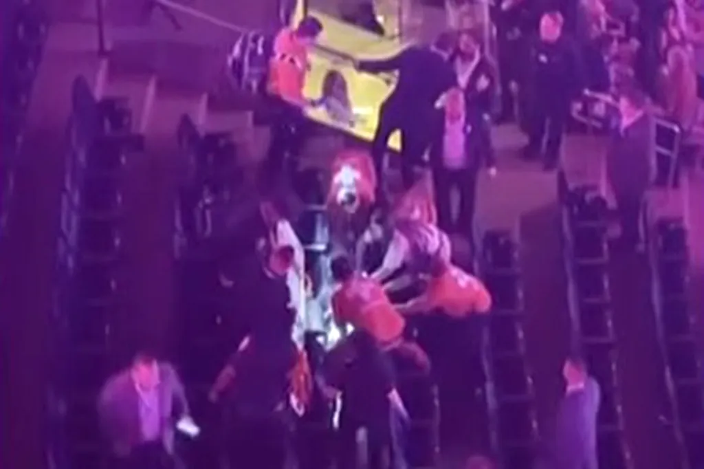 Security and concert-goers assist an injured Paul Keuker at Madison Square Garden.