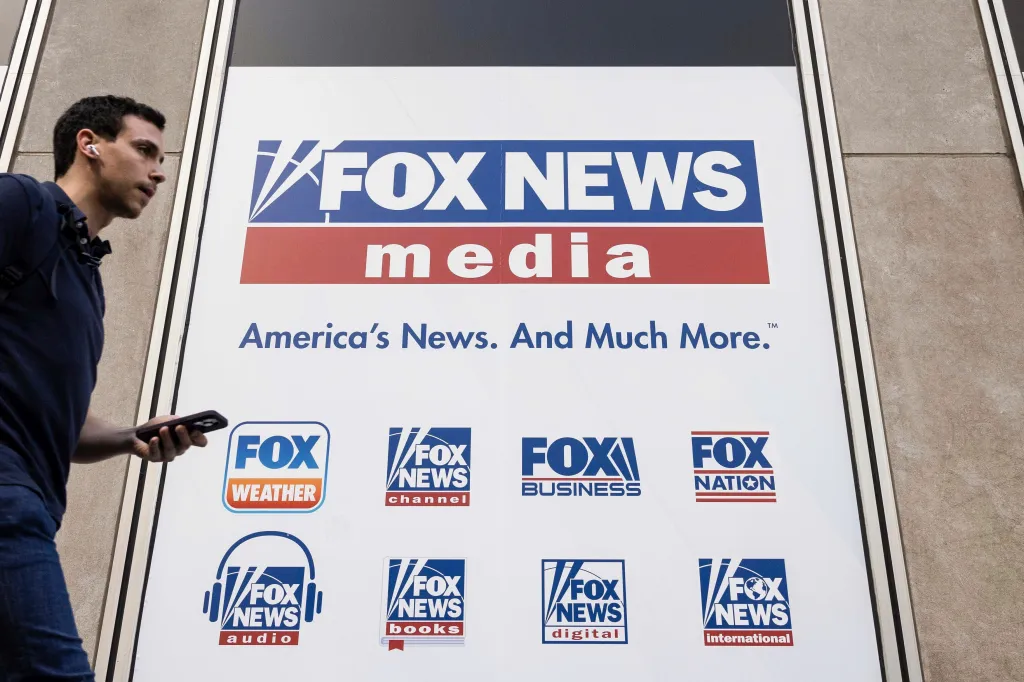 A person walks past the Fox News Headquarters sign in New York City.