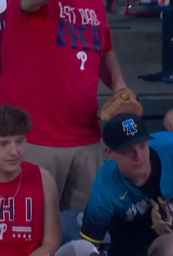 A Phillies fan who caught Mets outfielder Carson Benge's home run ball reaches down for a different ball on June 21, 2026.