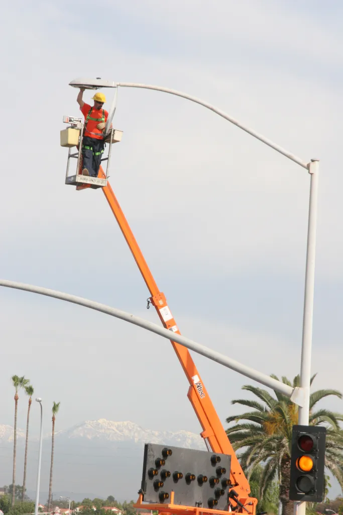 A city worker on a lift fixing street lights in Huntington Beach.