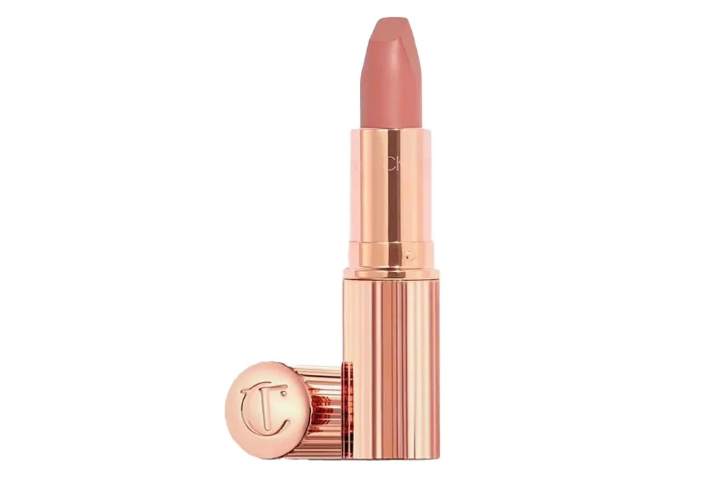 Rose gold lipstick with a peach-nude shade and the cap showing a “C” initial.