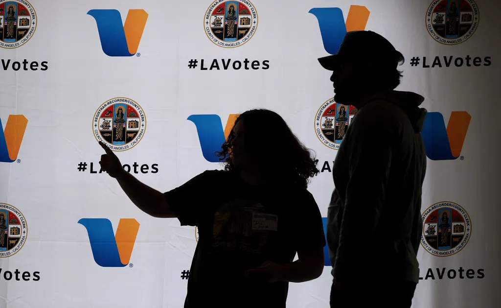 A polling worker helps direct a voter, right, at Beverly Hills City Hall on Tuesday, June 2, 2026. 