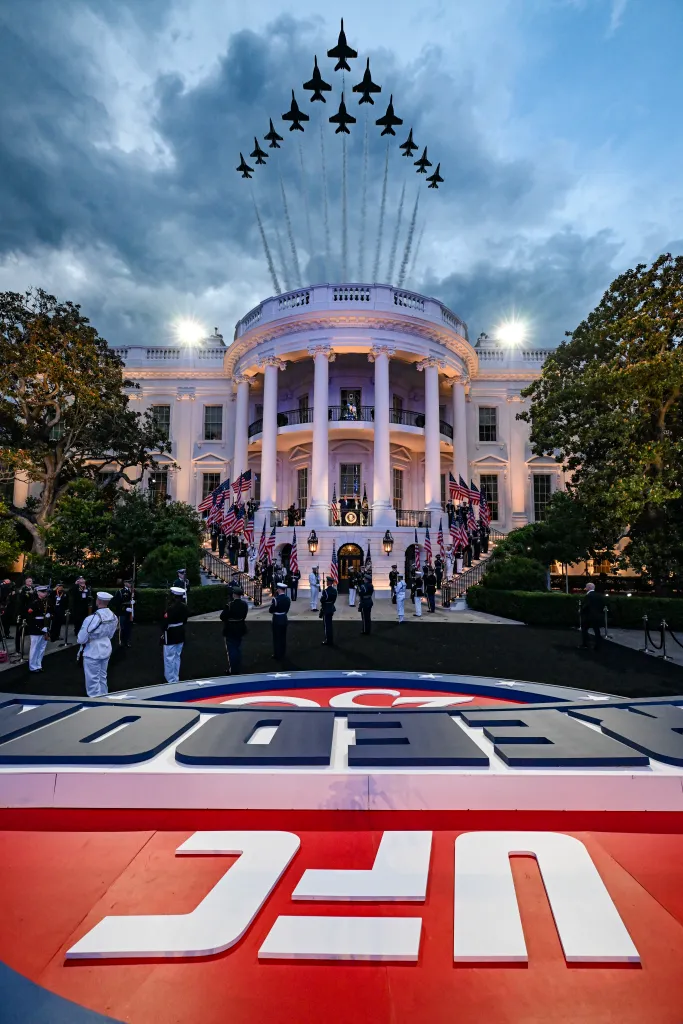 The White House illuminated at dusk with a large UFC logo in the foreground, and a flyover of 12 military jets in formation.