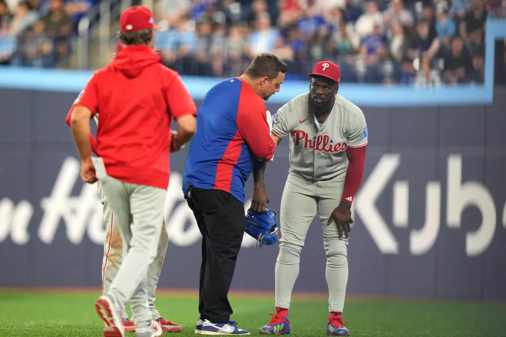 Adolis Garcia of the Philadelphia Phillies receiving treatment on the field.