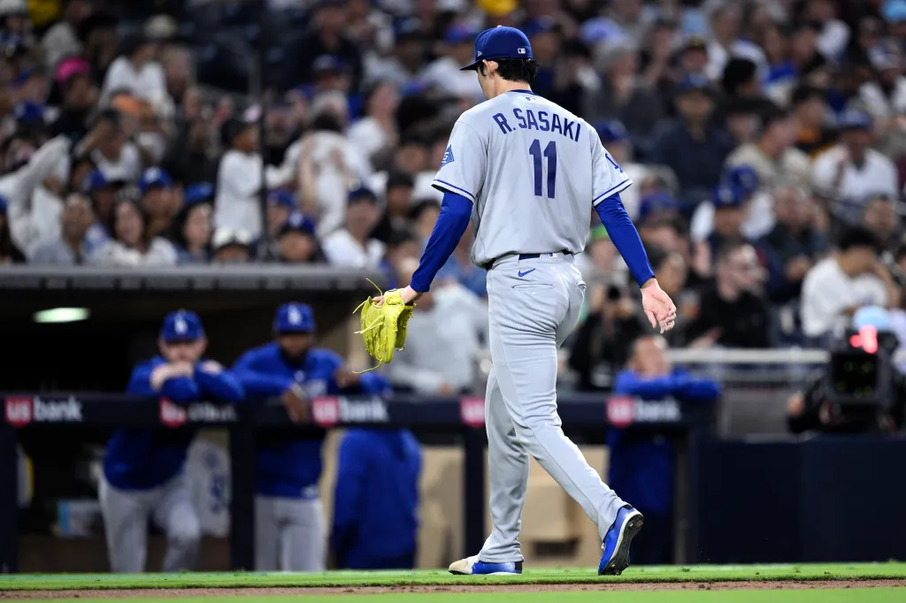 Roki Sasaki walking off the field after being replaced by another pitcher.