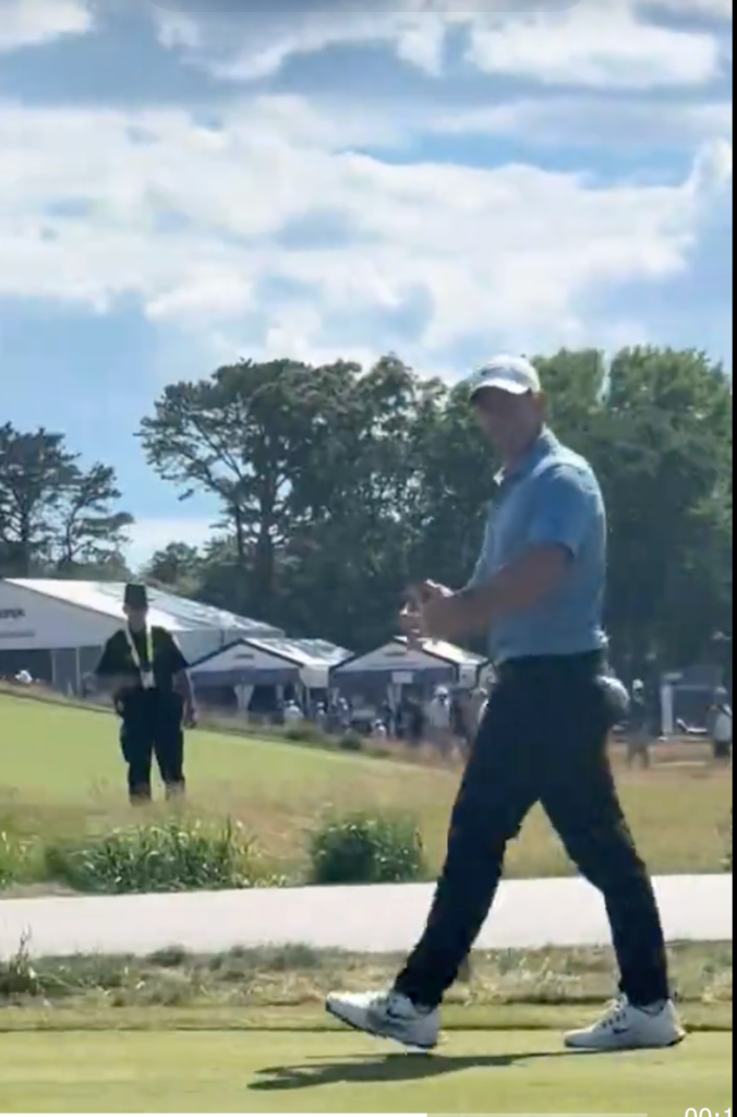 Rory McIlroy walking across the green.