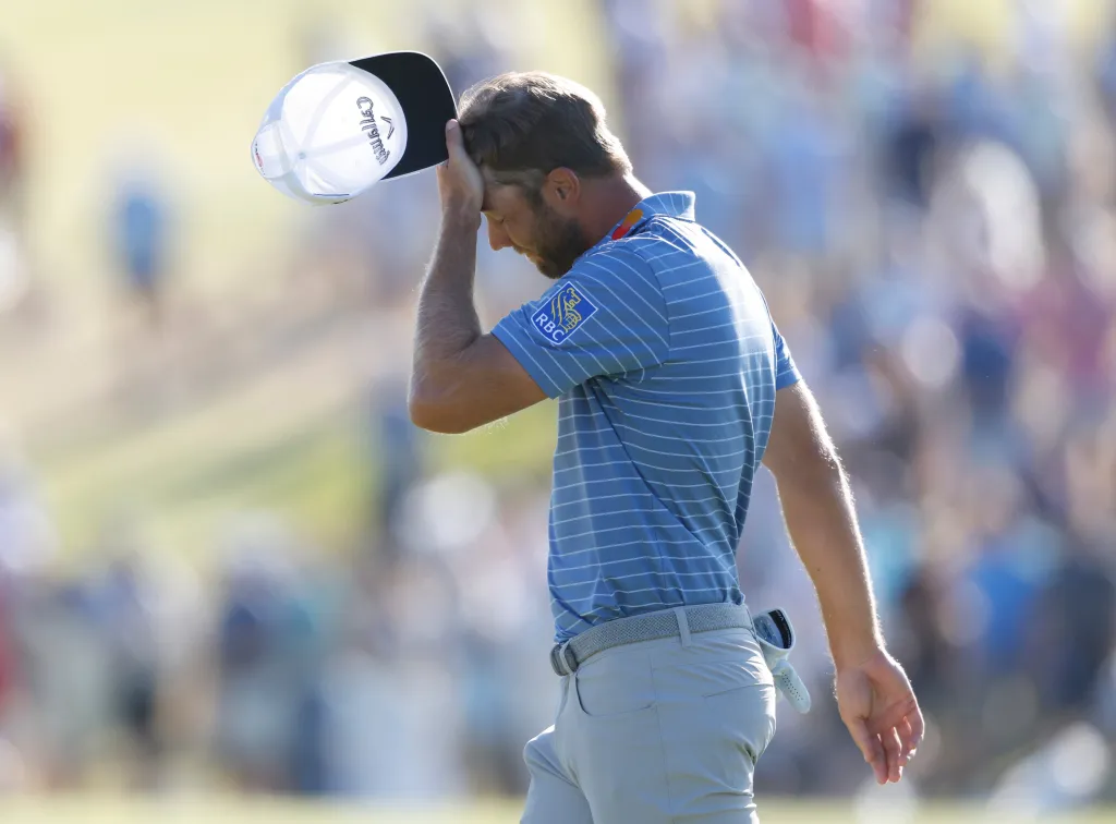Golfer Sam Burns reacts after missing a putt on the 18th hole.