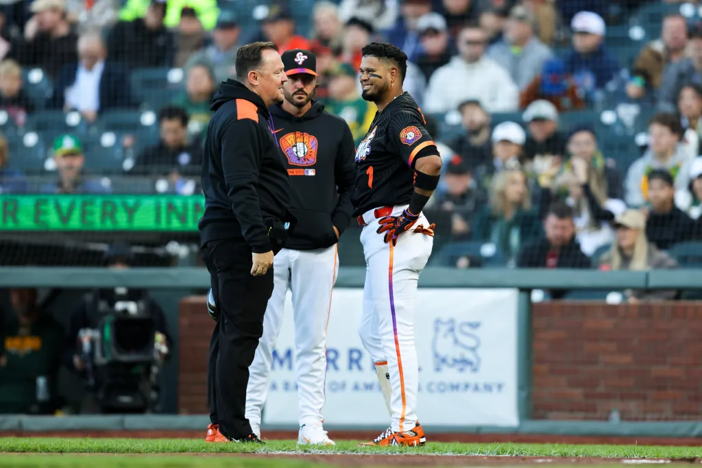 San Francisco Giants second baseman Luis Arraez talks with manager Tony Vitello and a trainer.