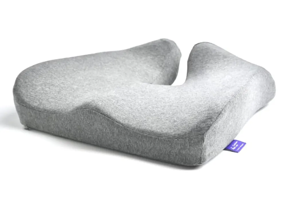 A gray ergonomic seat cushion with a cutout at the back.