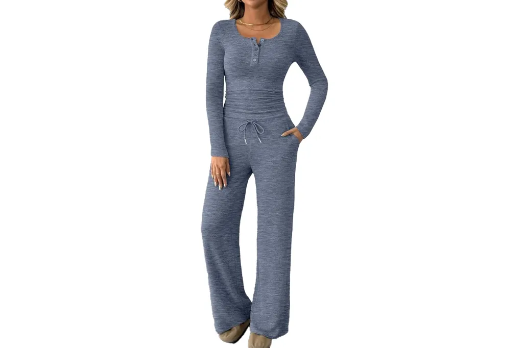 A woman wearing a blue long-sleeved shirt with buttons and matching blue pants with a drawstring and pockets.