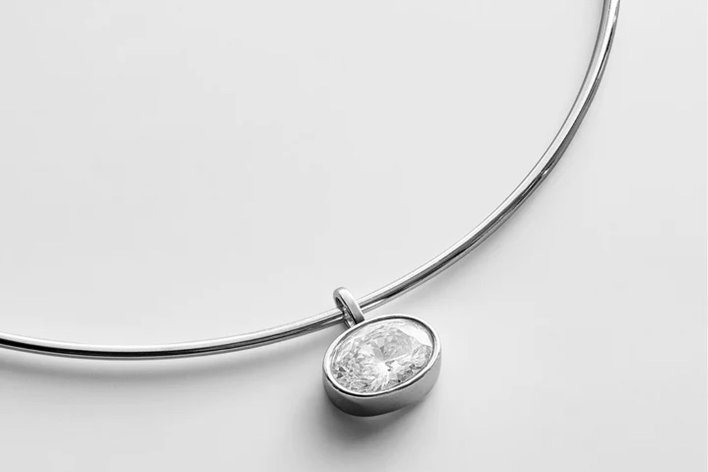A silver necklace with a large, oval-cut diamond pendant.