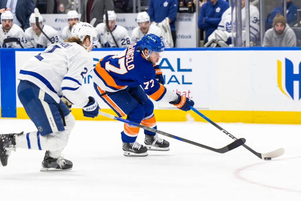New York Islanders defenseman Tony DeAngelo (77) skates with the puck, facing Toronto Maple Leafs defenseman Simon Benoit (2) during the first period at UBS Arena.