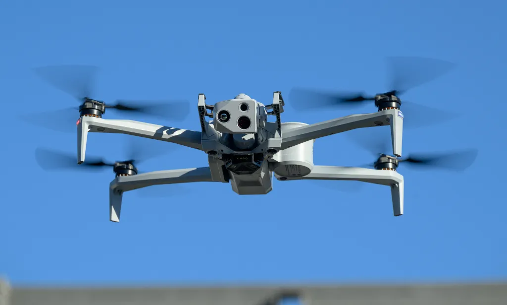 Skydio X10 drone flying against a clear blue sky.