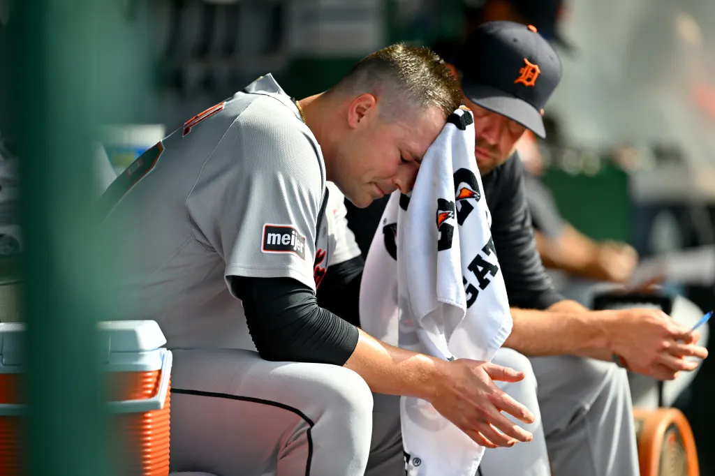 Detroit Tigers pitcher Tarik Skubal wipes his face with a towel in the dugout.