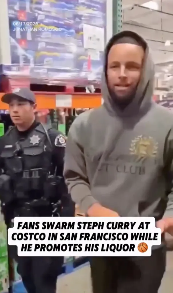 Steph Curry in a grey hoodie, accompanied by a police officer, promotes his liquor at Costco in San Francisco.