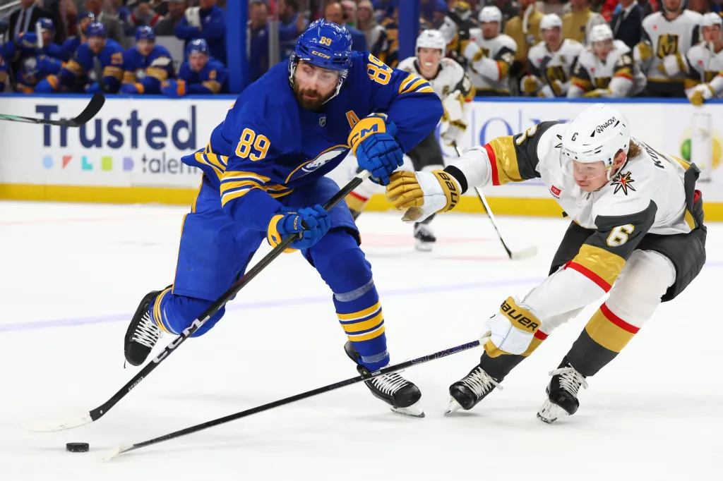 Buffalo Sabres right wing Alex Tuch (89) is stick-checked by Vegas Golden Knights defenseman Kaedan Korczak (6) during an NHL hockey game.