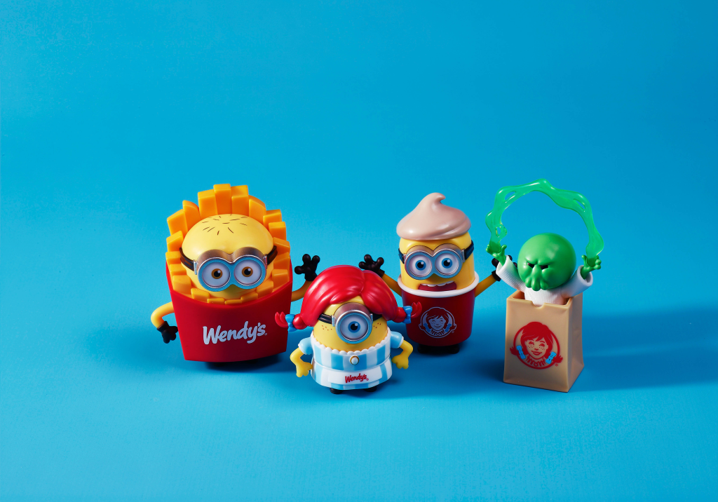 Four Minions figures dressed in Wendy's themed outfits against a blue background.