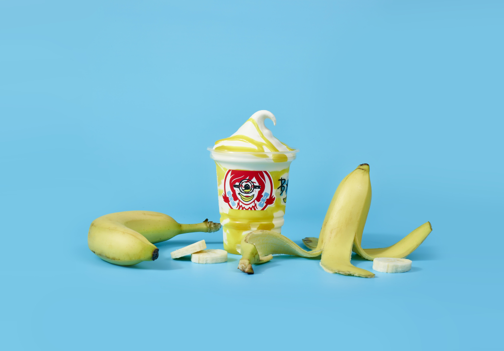 Wendy's Banana Frosty Swirl in a Minions cup with bananas and banana slices on a blue background.