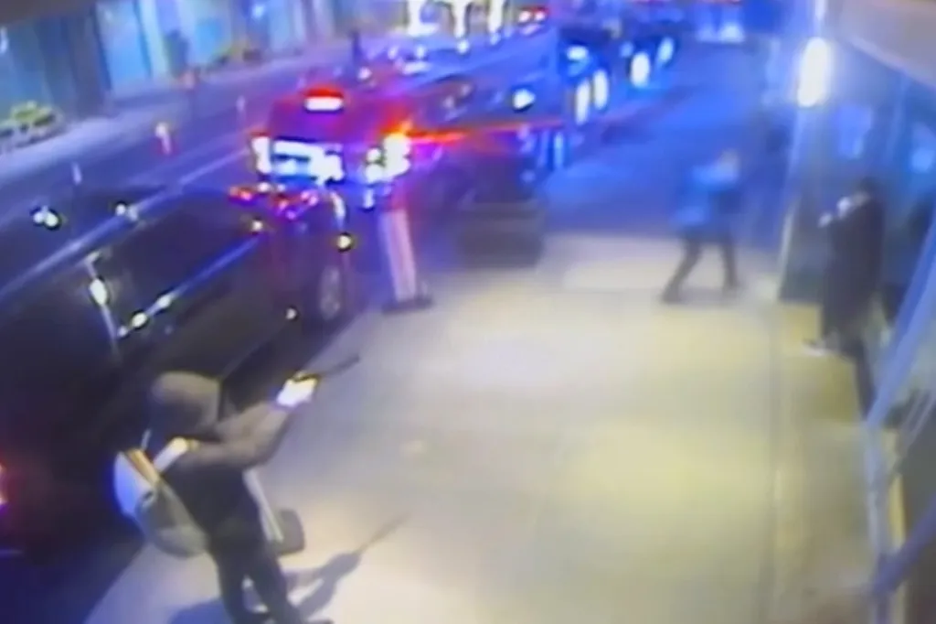 Surveillance footage of Luigi Mangione, a suspect in the murder of UnitedHealthcare CEO Brian Thompson, aiming a gun.