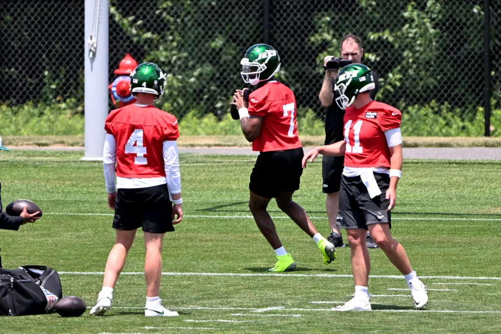 Jets quarterback Geno Smith (7) throws the football as Brady Cook (4) and Bailey Zappe (11) look on during minicamp.