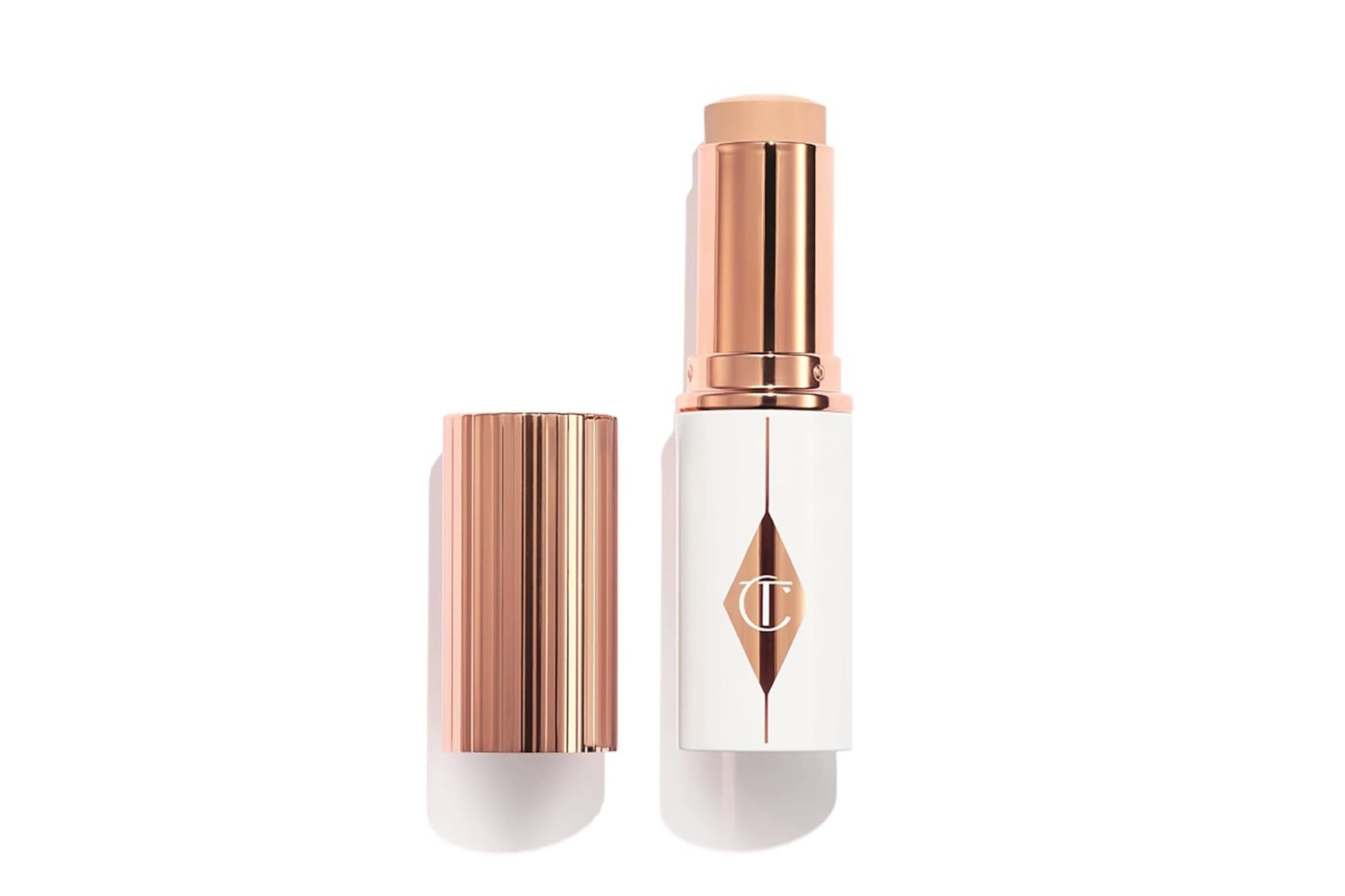 A Tilbury foundation stick, open to show the makeup color, and its cap.