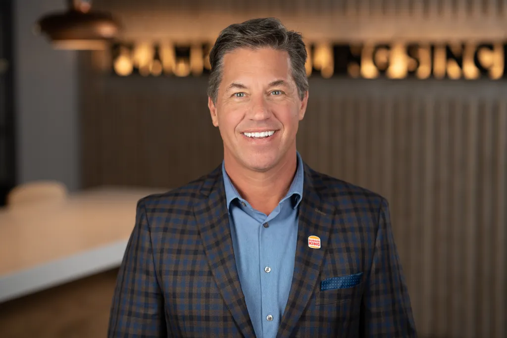 Tom Curtis, CEO of Burger King, smiles at the camera.