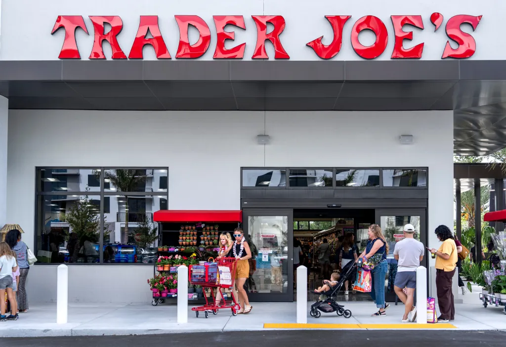 Exterior of a new Trader Joe's grocery store with customers entering and exiting.