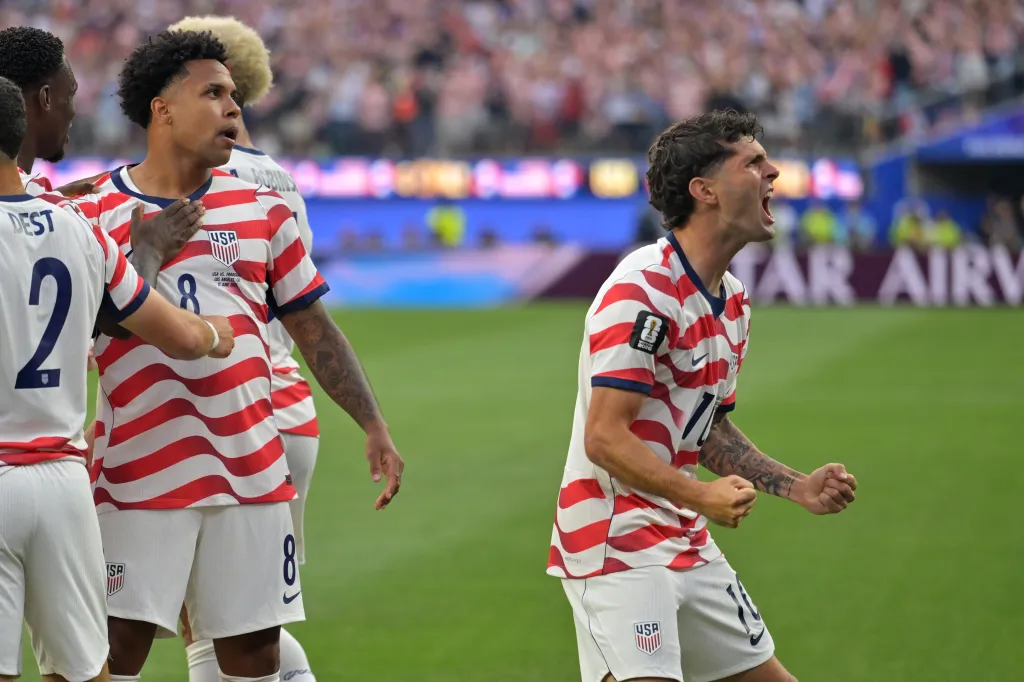 Christian Pulisic, right, celebrates with teammates after an own goal by Paraguay's Damian Bobadilla during the World Cup Group D soccer match in Inglewood, Calif., near Los Angeles, Friday, June 12, 2026.